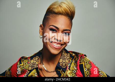 Closeup portrait of happy female hipster in fashionable casual shirt against gray background Stock Photo