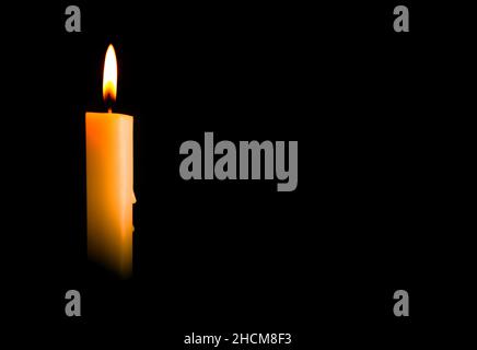 Candle light burning brightly in the black background, blank and wide background for copy space. Stock Photo