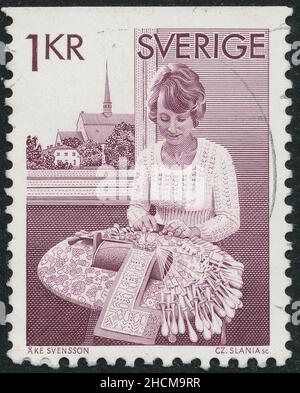 POLTAVA, UKRAINE - Desember 30, 2021. Vintage stamp printed in Sweden circa 1974 shows woman makes lace Stock Photo