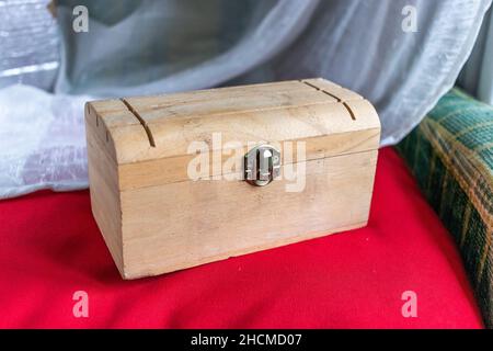 Wooden box on a red velvet cushion Stock Photo