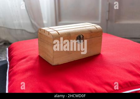 Wooden box on a red velvet cushion Stock Photo