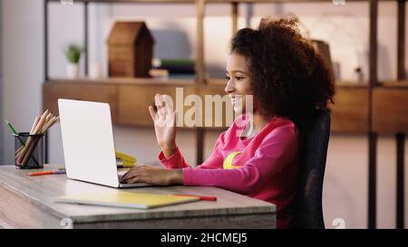 African kid girl waving hand video call remote learning on laptop ...