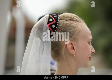 Braila, Romania - August 26, 2021:Shallow depth of field (selective focus) details with a girl dressed in Romanian traditional clothing. Stock Photo