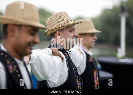 Braila, Romania - August 26, 2021: Men dressed in Romanian traditional costumes perform a traditional dance. Stock Photo