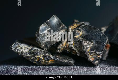 Shungit is a black rock that consists mainly of carbon and was photographed in top quality and studio quality. Stock Photo