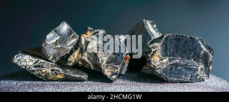 Shungit is a black rock that consists mainly of carbon and was photographed in top quality and studio quality. Stock Photo