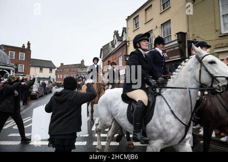 Bungay, Suffolk, UK. 27th December 2021. Pictured: Animal rights activists attempt to block members of the hunt riding through the streets of Bungay. Stock Photo