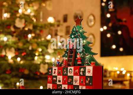 Three-dimensional Advent Calendar with stylised Christmas Tree in the middle of Christmassy decorated Family Room Stock Photo