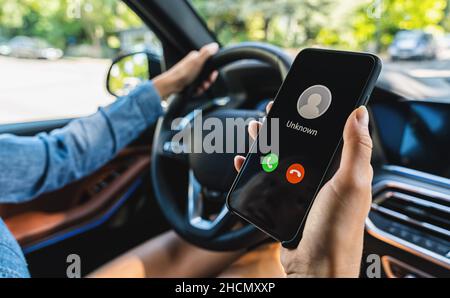 Rear view of attractive young woman in casual wear looking carefully to the road while driving a car. Stock Photo