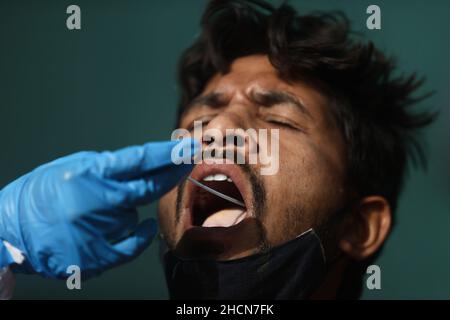 New Delhi, New Delhi, India. 30th Dec, 2021. A healthcare worker collects a coronavirus disease (COVID-19) test swab sample from a passenger amidst the spread of the disease, at a railway station. (Credit Image: © Karma Sonam Bhutia/ZUMA Press Wire) Stock Photo