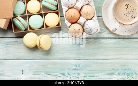 Homemade macaroons in gift box and easter eggs. Top view flat lay with copy space Stock Photo