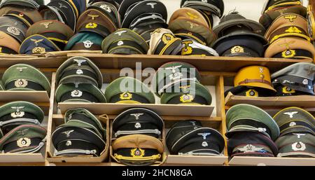 Various WW2 German caps on display for sale including Army visor caps, Wraffen-SS caps, Luftwaffe caps and Allgemeine caps. Stock Photo