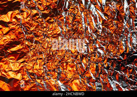 crumpled foil background illuminated with colored lights Stock Photo