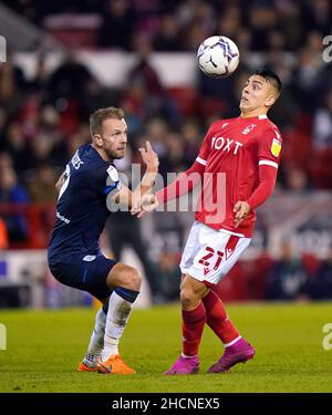 Huddersfield Town's Jordan Rhodes (left) and Nottingham Forest's Braian Ojeda battle for the ball during the Sky Bet Championship match at the City Ground, Nottingham. Picture date: Thursday December 30, 2021. Stock Photo
