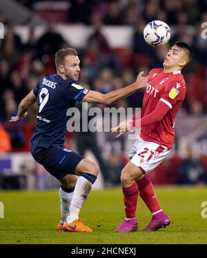 Huddersfield Town's Jordan Rhodes (left) and Nottingham Forest's Braian Ojeda battle for the ball during the Sky Bet Championship match at the City Ground, Nottingham. Picture date: Thursday December 30, 2021. Stock Photo