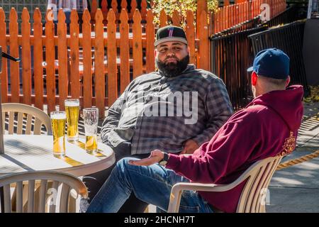 Two male beer drinkers sitting at a patio Stock Photo