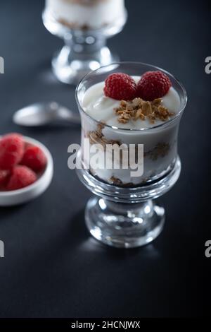 Helsinki / Finland - DECEMBER 30, 2021: Two glass bowls of vanilla yogurt with cinnamon roll granola and raspberry topping Stock Photo