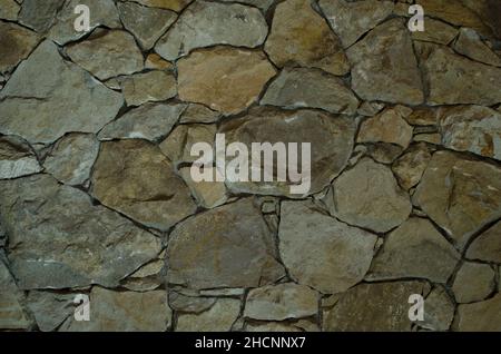 stone wall background and texture, stone blocks together. forming a wall of a rustic stone house Stock Photo