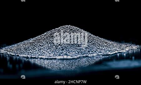 Pile of rocks isolated on black background. Close up of tiny black pieces of gravel lying on a flat reflecting surface, concept of construction materi Stock Photo