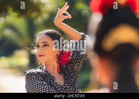 Selective focus on a beauty hispanic woman dancing flamenco in a park Stock Photo