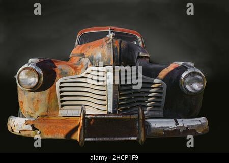 Rusted-out antique vehicle isolated on black with fog Stock Photo