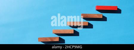 Wooden blocks in form of ladder upstairs red on dove background Stock Photo