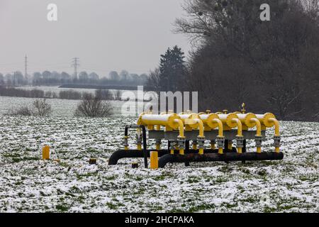 Yellow gas infrastructure elements sticking out of the ground. Winter photo of a snow-covered gas pipeline. High natural gas prices. The photo was tak Stock Photo