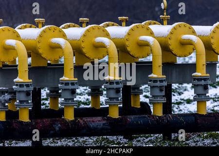 Yellow gas infrastructure elements sticking out of the ground. Winter photo of a snow-covered gas pipeline. High natural gas prices. The photo was tak Stock Photo