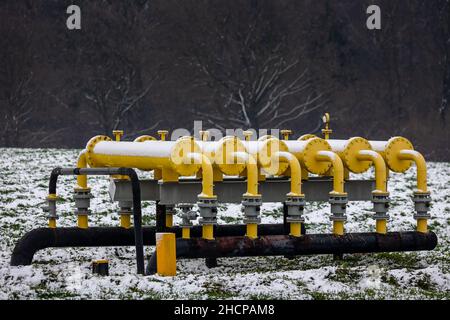 Yellow gas infrastructure elements sticking out of the ground. Winter photo of a snow-covered gas pipeline. High natural gas prices. The photo was tak Stock Photo