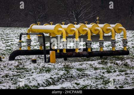 Yellow gas infrastructure elements sticking out of the ground. Winter photo of a snow-covered gas pipeline. High natural gas prices. The photo was tak Stock Photo