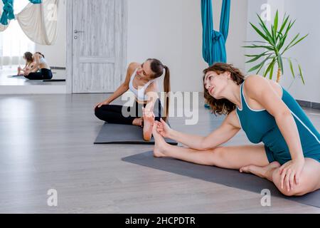 Yoga. Two young women practicing yoga poses. Partner yoga. Stock Photo