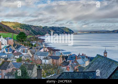 A long reaching landscape over the rooftops of Kingsand village in Cornwall, England, looking North along the shoreline to Plymouth on a Winters day. Stock Photo