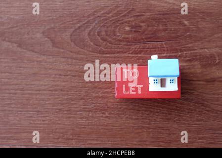 Selective focus image of miniature house and text TO LET. Real estate and property concept. Stock Photo