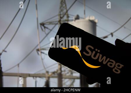Rheinbach, Germany  5 October 2021,   The brand logo of the energy supplier 'Süwag' on the display of a smartphone in front of a transformation Stock Photo