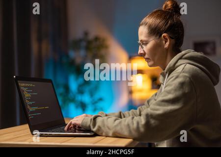 Woman using laptop for coding Stock Photo