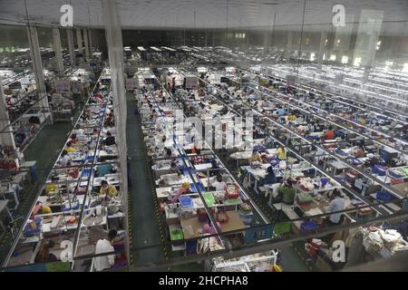 (211231) -- PHNOM PENH, Dec. 31, 2021 (Xinhua) -- Garment workers make clothes at a factory in Phnom Penh, Cambodia on Dec. 17, 2021. Officials and experts said Cambodia has pinned high hope on the Regional Comprehensive Economic Partnership (RCEP) and the Cambodia-China Free Trade Agreement (CCFTA) to boost its economic growth in the post-COVID-19 pandemic era. The two free trade deals are due to enter into force on Jan. 1, 2022. Enjoy Ho, deputy chairman of the Garment Manufacturers Association in Cambodia, said the two deals would bring about better development for Cambodia's textile and g Stock Photo