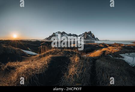 Aerial drone view of sunset runrise and gorgeous reflection of Vestrahorn mountain on Stokksnes cape in Iceland. Beautiful snow covered mountains Stock Photo