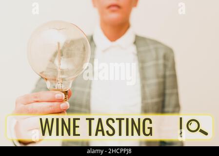 Conceptual caption Wine Tasting. Internet Concept Degustation Alcohol Social gathering Gourmet Winery Drinking Lady in business outfit holding lamp Stock Photo