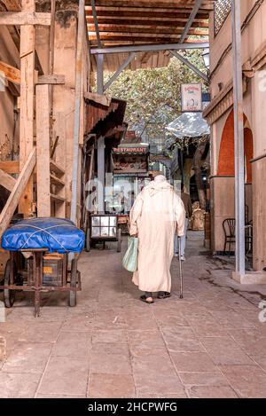 Rear view of old man in traditional djellaba walking on street Stock Photo