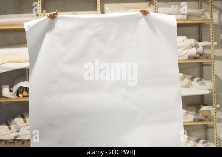 Technician worker operator show and point blank empty space of white paper on large premium industrial printer and plotter machine in digital printsho Stock Photo