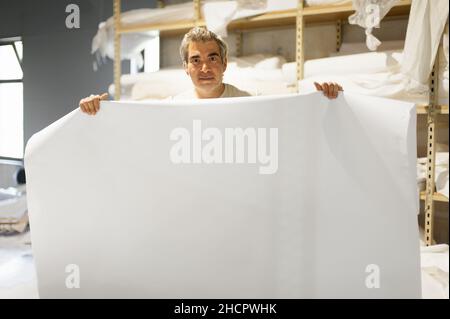 Technician worker operator show and point blank empty space of white paper on large premium industrial printer and plotter machine in digital printsho Stock Photo