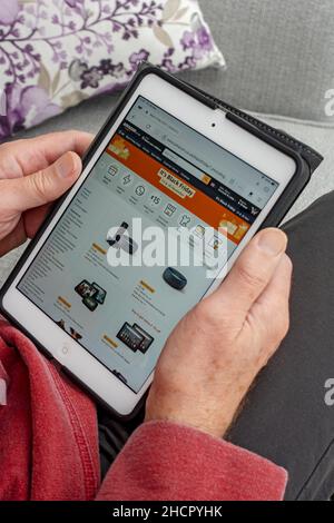 Close up of man person looking at Amazon Black Friday shopping website on a ipad tablet screen England UK United Kingdom GB Great Britain Stock Photo