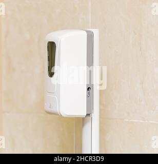 Automatic non-contact hand sanitizer dispenser in public places. Close-up. Stock Photo