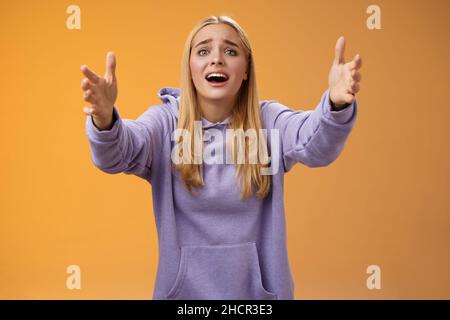 Excited fascinated glad blond woman adore singer performing stage extend arms forward reaching camera wanna hold tight cuddle embrace love open mouth Stock Photo