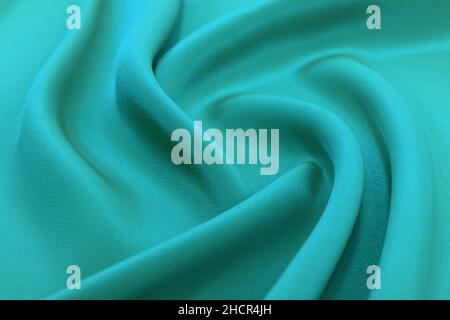 Background from a crumpled piece of green fabric with waves. Textile. Sewing material Stock Photo