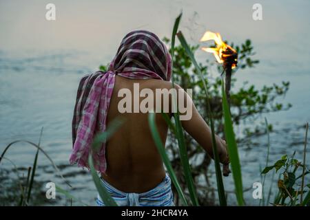 a man in Sundarban  river side with a fire torch . Stock Photo