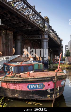 UK, England, Manchester, Castlefield, Bridgewater Canal basin, residential canal narrowboat  Irwell below railway viaduct crossing Stock Photo