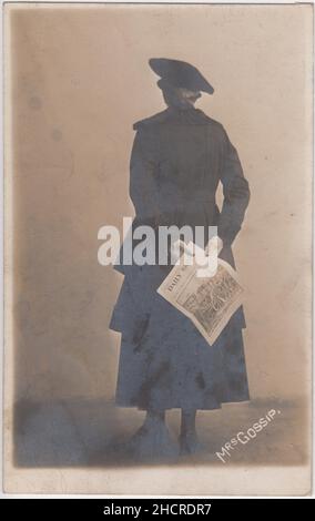 'Mrs Gossip': photograph of a woman with her back turned to the camera, she is holding a copy of the Daily Sketch which has a large photo of First World War soldiers on the front and the caption 'How Tommy shifted Downing St' Stock Photo