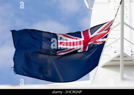 Mast array of the Cunard Queen Elizabeth cruise liner showing the Blue Ensign flag in the wind. Stock Photo