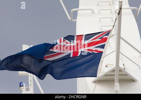 Mast array of the Cunard Queen Elizabeth cruise liner showing the Blue Ensign flag in the wind. Stock Photo